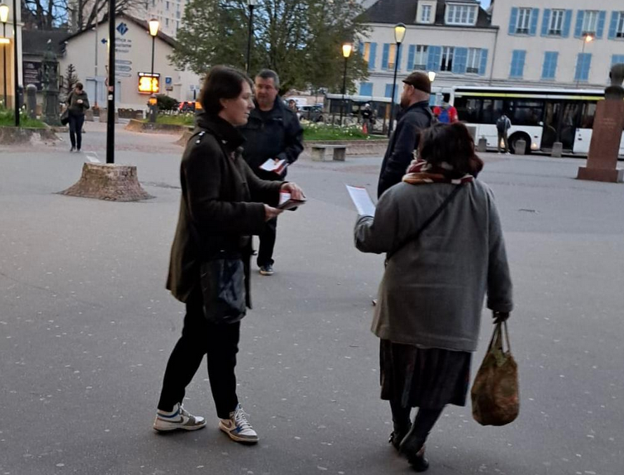 personnes distribuant des tracts sur le parvis gare de Poissy